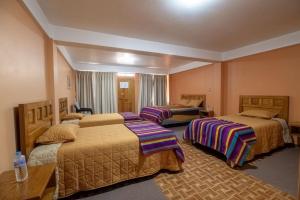 a hotel room with three beds in a room at La Chacana Hotel Boutique in Huaraz