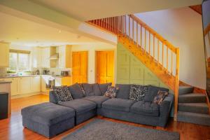 a living room with a couch and a staircase at Maple Lodge in Knighton