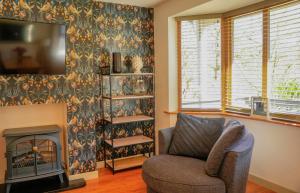 a living room with a chair and a fireplace at Maple Lodge in Knighton