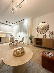 a living room with a table and a kitchen at Apartament Moje Moderato II w Starogardzie Gdańskim in Starogard Gdański