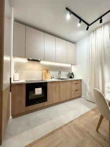 a kitchen with white cabinets and a sink at Apartament Moje Moderato II w Starogardzie Gdańskim in Starogard Gdański +10 photos