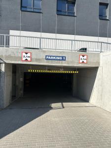 a tunnel with a parking sign in front of a building at Apartament Moje Moderato II w Starogardzie Gdańskim in Starogard Gdański