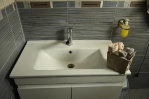 a bathroom sink with a faucet on top of it at Mustache 3 Room Apt City Center in Bitola +57 photos