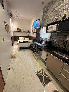 a room with a kitchen and a living room with a couch at Flat jk 03 térreo in Juazeiro do Norte