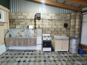 an old kitchen with a stove and a sink at Rest House in Quba