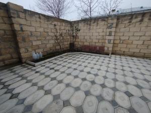 a room with a brick wall and a tiled floor at Rest House in Quba