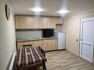 a small kitchen with a table and a refrigerator at Rest House in Quba +5 photos