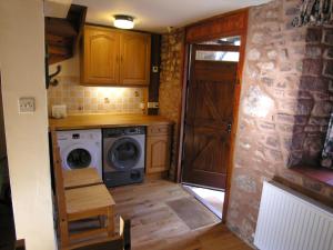a small kitchen with a washing machine and a door at Selworthy- Ukc4915 in Timberscombe