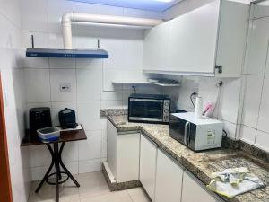 a kitchen with a counter top with a microwave at Flat Lagoa Santa in Lagoa Santa