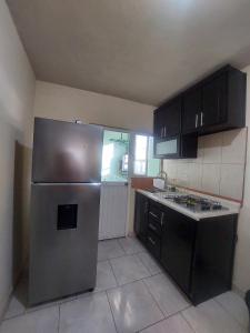 a kitchen with a stainless steel refrigerator and black cabinets at Casa Verano in Guanajuato