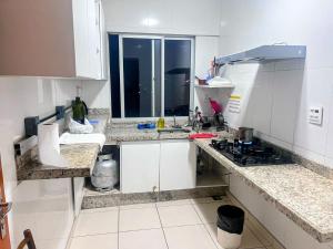 a small kitchen with white cabinets and a stove at Flat Lagoa Santa in Lagoa Santa +4 photos