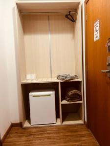 a closet with a small white refrigerator in a room at Flat Lagoa Santa in Lagoa Santa