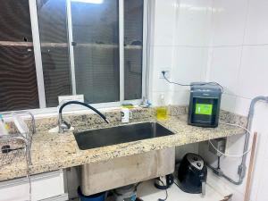 a kitchen counter with a sink and a window at Flat Lagoa Santa in Lagoa Santa