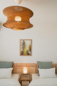 a room with two beds and a chandelier at Guesthouse tontonmie in Gimbaru