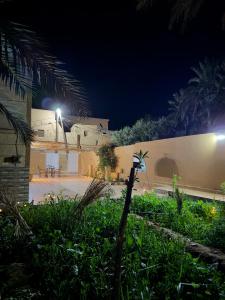 a building with a courtyard at night with lights at Villa Palm Desert- your Private Stay with AC, Fast WiFi & Parking in Erfoud