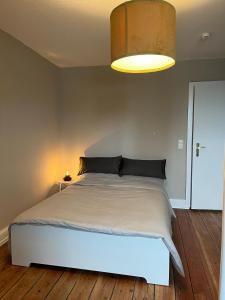 a bedroom with a large bed with a light above it at Justs Place in Garding