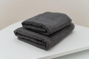 a pile of grey towels sitting on a shelf at Guesthouse tontonmie in Gimbaru +49 photos