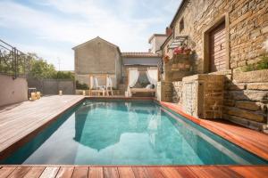 a swimming pool with a wooden deck next to a building at Istrian Perfect Life in Šmarje