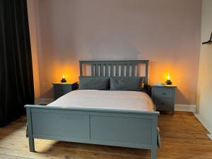 a bedroom with a blue bed with two night stands at Hannas Place in Garding