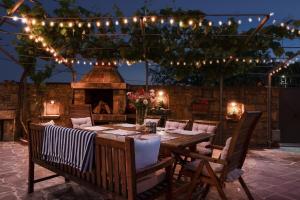 a wooden table and chairs with a fireplace and lights at Istrian Perfect Life in Šmarje