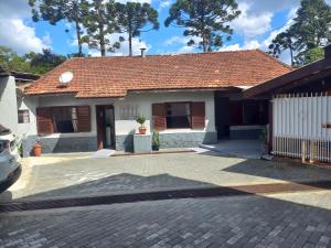 a house with a red roof and a driveway at Casa Recanto 2 in Campos do Jordão