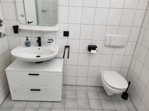a white bathroom with a sink and a toilet at Amtsstube1892 - Übernachten im alten Gefängnis in Überlingen +9 photos