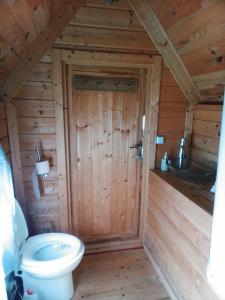 a bathroom with a toilet in a wooden cabin at kota en Normandie in Couvains