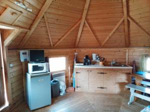 a kitchen with a stove and a refrigerator in a cabin at kota en Normandie in Couvains