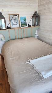 a bed in a room with pictures on the wall at Chambre avec vue sur mer in Saint Malo