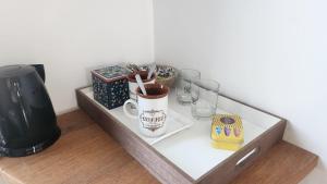a shelf with a cup of coffee and glasses on it at Chambre avec vue sur mer in Saint Malo