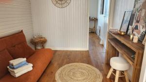 a living room with a couch and a stool at Chambre avec vue sur mer in Saint Malo