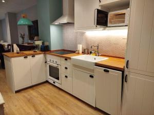 a kitchen with white cabinets and a sink at R2R - Apartamento cerca del mar - 14A12 in Lastres +5 photos