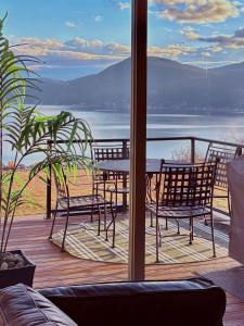 a table and chairs on a deck with a view of the water at Exceptional Boutique Cottage with Incredible Lake & Vineyard Views at La Casa Resort - Sleeps 6 in Kelowna