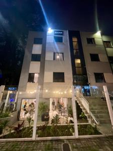 a building with people sitting outside of it at night at Social Hostel Café e Bar in Curitiba