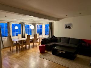 a living room with a couch and a table at Apartments with Panoramic Views in Longyearbyen