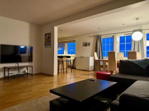 a living room with a couch and a table at Apartments with Panoramic Views in Longyearbyen