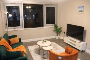 a living room with a couch and a tv at Stunning Sea View 2BR Flat Sleeps 5 Walk to Beach - Big Savings for Extended Stays - by Nestora Stays Ltd in Brighton & Hove
