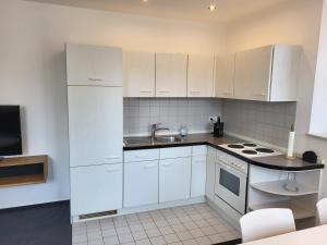 a kitchen with white cabinets and a sink at Amtsstube1892 - Übernachten im alten Gefängnis in Überlingen