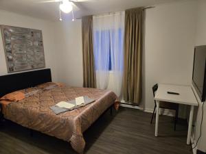 a hotel room with a bed and a desk and a television at Brossard home in Brossard +8 photos