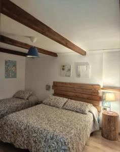 a bedroom with two beds and a wooden headboard at L'Armonica di Nonno Sandro in Corfinio