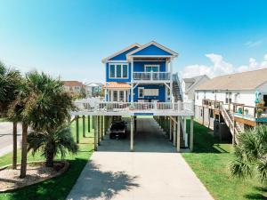 a house on a dock with palm trees at Paws and Relax! in Carolina Beach