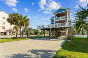 a house with a balcony and palm trees at Paws and Relax! in Carolina Beach +71 photos