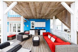 a living room with a red couch on a deck at Paws and Relax! in Carolina Beach