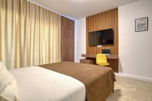 ein Hotelzimmer mit Bett und Flachbildfernseher in der Unterkunft Gama residence in Becici