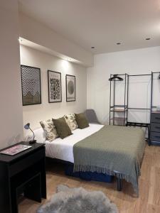 a bedroom with a bed and a desk and a ladder at Apartamentos Bajo La Viga con Piscina in Salamanca