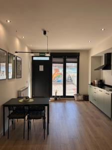 a kitchen with a table and chairs in a room at Apartamentos Bajo La Viga con Piscina in Salamanca