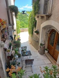 an outdoor patio with chairs and plants and a door at L'Armonica di Nonno Sandro in Corfinio