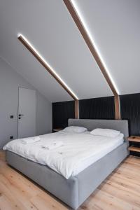 a bedroom with a large bed with white sheets at GoldHill villas 9 in Yaremche +48 photos