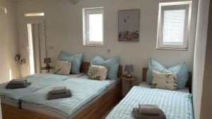 a bedroom with two beds and two windows at Apartmány U BERANA in Česká Lípa