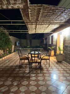 a patio with two chairs and a table in a building at Villa Palm Desert- your Private Stay with AC, Fast WiFi & Parking in Erfoud